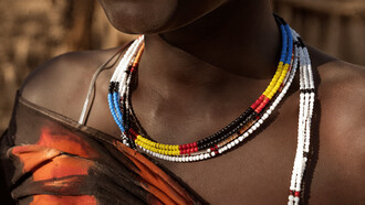 A close-up of beadwork worn by a woman, representing cultural identity and personal history