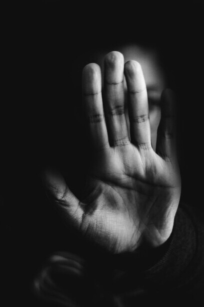 An individual holding his hand out to stop people from saying yes without thinking