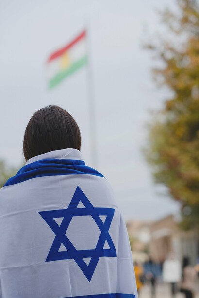 A person with the Israeli flag over their shoulders