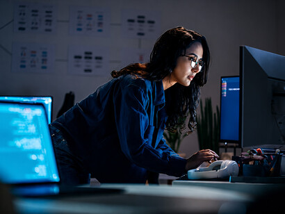 Software engineer working on code during a late-night session with AI chatbot support