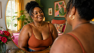 A woman meeting her own gaze with kindness, reflecting the beauty of self-awareness rooted in acceptance