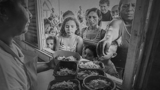 Fila de pessoas em programa social brasileiro. O mercado de trabalho mostra avanços insuficientes para sustentar crescimento. A informalidade continua elevada; os rendimentos têm progresso limitado; e parte significativa das vagas criadas oferece baixa estabilidade. Esse cenário é reflexo de um histórico de estagnação produtiva, que limita a criação de empregos qualificados e mantém grande parte dos trabalhadores em condições precárias. Para as famílias, o custo de vida se mantém alto, mesmo em períodos de inflação controlada. O preço de itens essenciais pressiona o orçamento doméstico e limita o consumo, criando sensação constante de aperto financeiro. Essa percepção pesa mais do que indicadores formais e alimenta frustração social