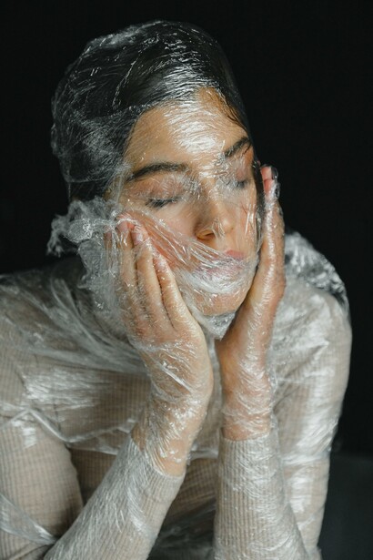 A woman whose face is covered in plastic
