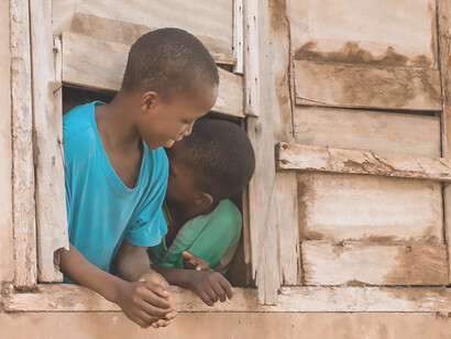 A group of African migrant children are photographed posing by a window in South Africa