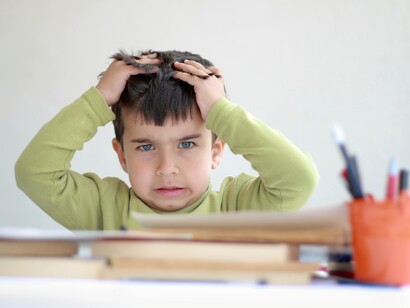 Niño desesperado ante los libros