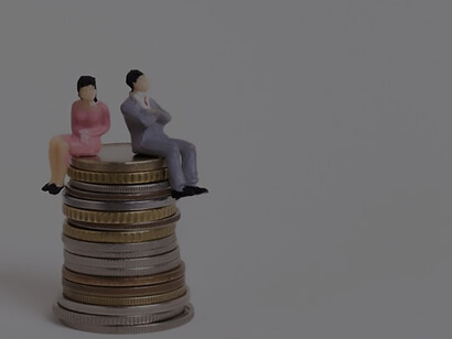 Strategic minds: business man and woman strategically seated on coins for financial success