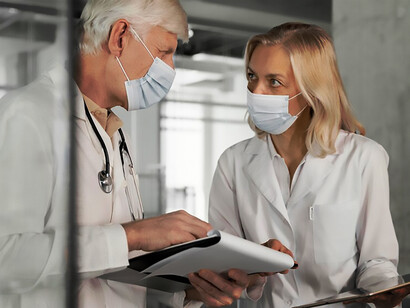 Physicians wearing medical masks engage in conversation about P4 medicine, highlighting personalized healthcare approaches