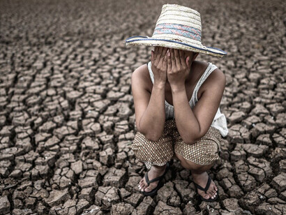 The girl sat alone, her hand lifted to the sky, pleading for rain to revive the thirsty soil suffering from the impacts of global warming