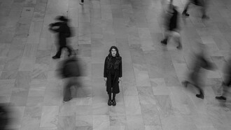 Lonely woman standing in a bustling New York terminal, USA