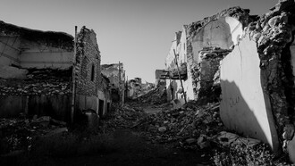 A ravaged city street, building turned to rubble