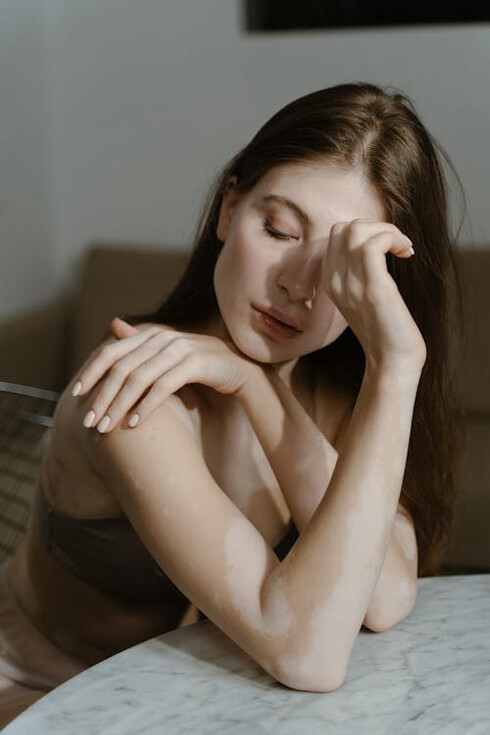 Alluring woman stroking her shoulder, comfortable in her own skin