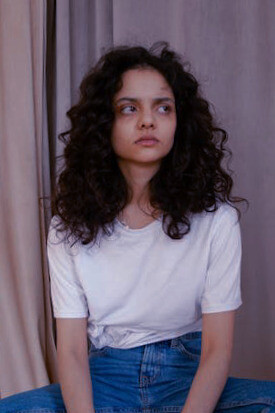 Amidst her contemplation, the girl embodies the significance of questioning authority and challenging assumptions, illustrating how critical thinking serves as a shield against manipulation and deception in both personal and political realms