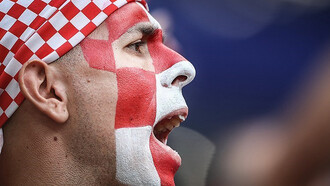 A passionate Croatia football supporter waves the national flag and cheers enthusiastically during an international football match, FIFA World Cup 2018 Final