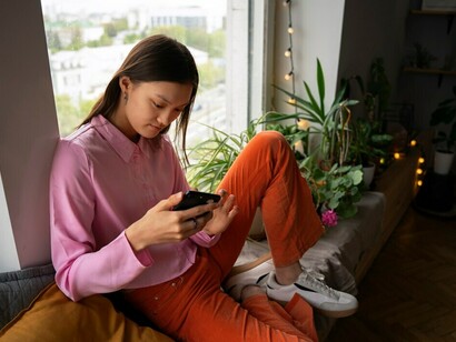 A girl lounging at home, messaging on dating apps, seeking new social connections in the digital dating world