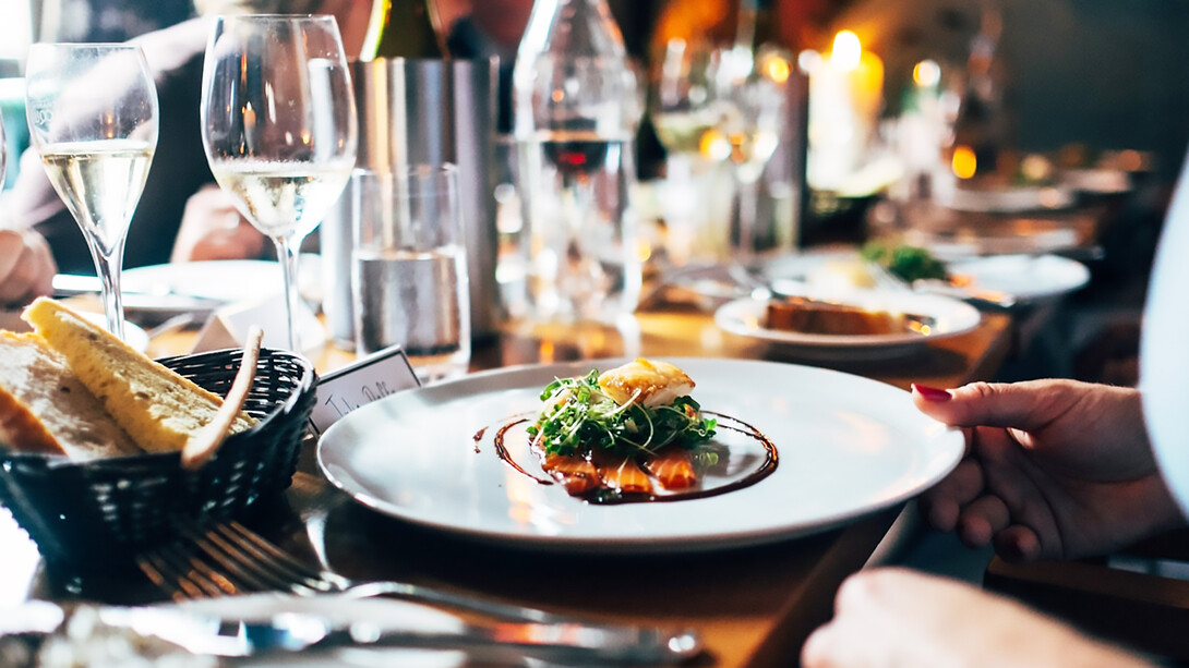 Gourmet meal with white wine on a white ceramic plate: European cuisine and food pairing for sensory dining experiences