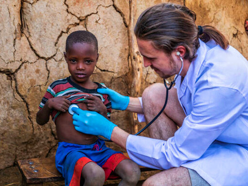 A Doctors Without Borders medical professional examines a young boy, exemplifying how NGOs actively contribute to filling the gaps left by government systems in times of crisis