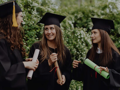In a moment of pride and achievement, three students stand adorned in their graduation robes and caps, symbolizing the successful completion of their university studies