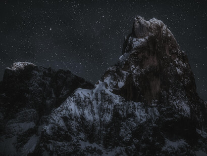A snowy mountain top during a clear, cold night