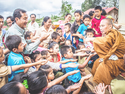 A monk giving to the people of a village
