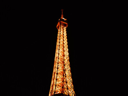 The fully illuminated tip of the Eiffel Tower, Paris, capital of France