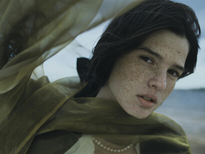 A woman with a green shawl staring into the camera