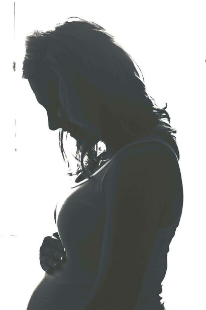 Expecting mother touches her baby bump