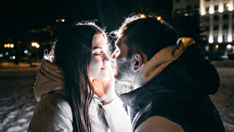 A loving couple embraces tenderly on a cold winter evening