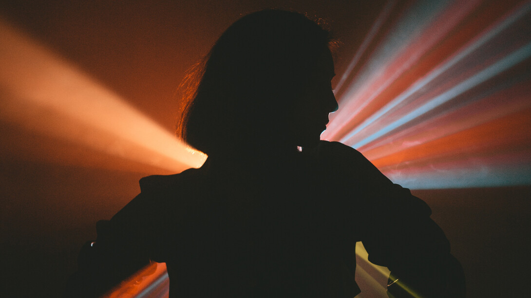 Feixos de luz criam uma silhueta sem gênero na noite clubber dos Estados Unidos