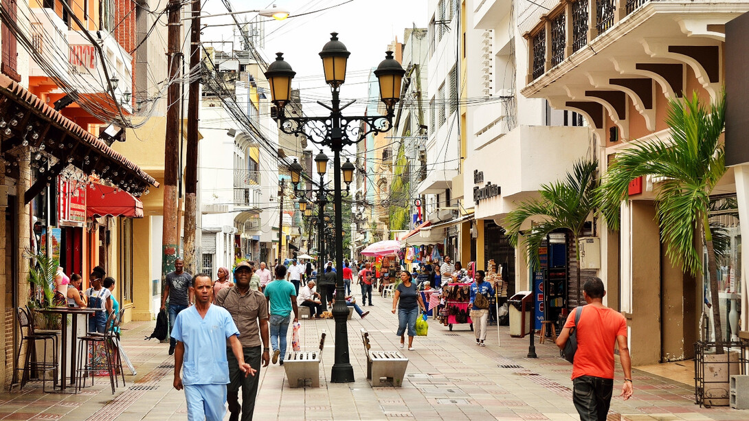 In the historic Ciudad Colonial district of Santo Domingo, Dominican Republic, pedestrians weave through markets and vendors, adding to the city's vibrant and bustling atmosphere