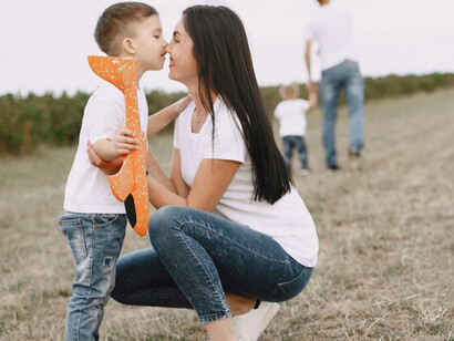 A mother and her little son playing with a toy plane, emphasizing self-expression, autonomy, and childhood independence