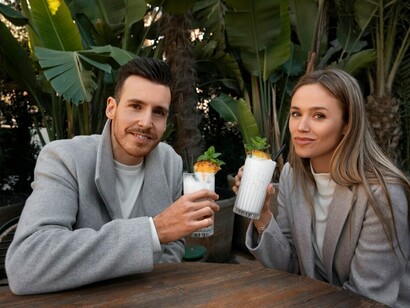 While enjoying pina coladas at a cozy café, a couple on their first date explores a dating app together