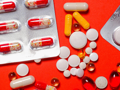 Different medication pills and tablets on a blister pack on a red background