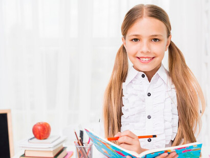 Schoolgirl studying at a desk with a pencil, emphasizing education for girls and the importance of school life