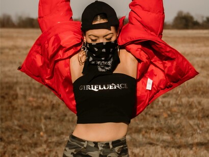 A woman wearing a black girl-influence top is posing for the right image to be posted on social media