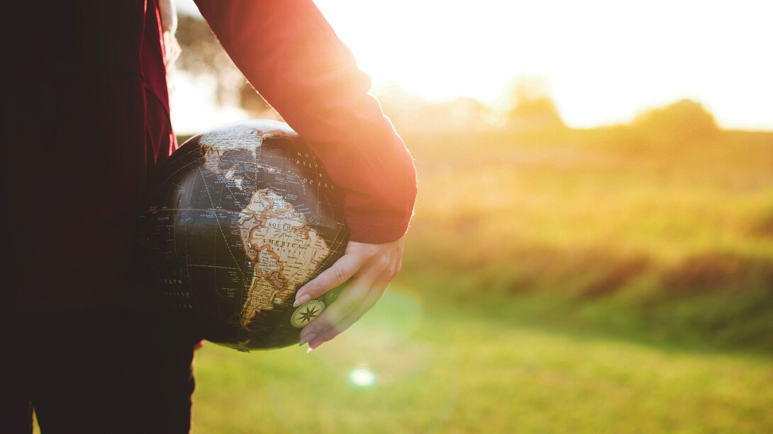 A woman with a globe in her hand represents the need for a global citizen approach to identity