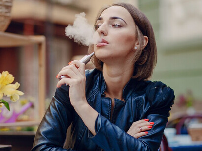 A woman enjoying a vape outdoors