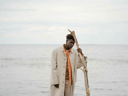 A lonely man due to population decline is leaning against a stick