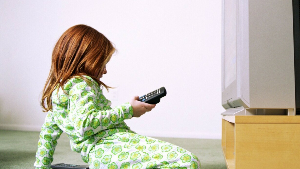 Una niña con el mando a distancia de la televisión