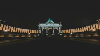 In Brussels, Belgium, the night unfolds under a deep, dark sky, framing a magnificent arch glowing in the distance