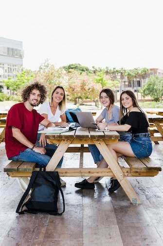 International students collaborating at a table, diving into their study abroad experience, cultural exchange, and exploring new cultures through travel adventure