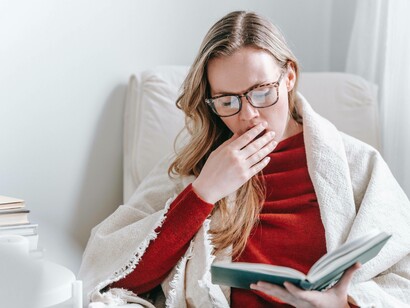 Woman covering her yawning face
