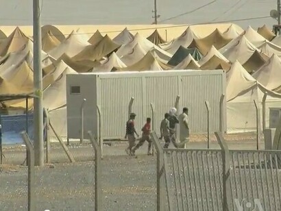 Tents at a Syrian refugee center on the Turkish border, set against the backdrop of Syria's war-torn landscape, illustrating the ongoing humanitarian disaster, Turkey