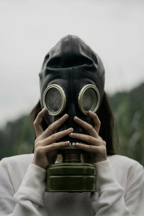 An individual donning a gas mask, ready to face potential hazards
