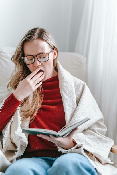 Woman covering her mouth as she yawns