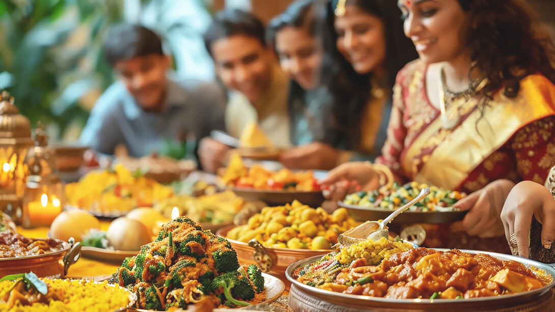 A family is enjoying a delightful meal of Indian cuisine, savoring the rich flavors and variety of traditional dishes together