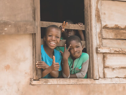 In South Africa, African migrant children striking a pose near a window