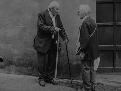 Two old people conversing on the street in Siena, Italy