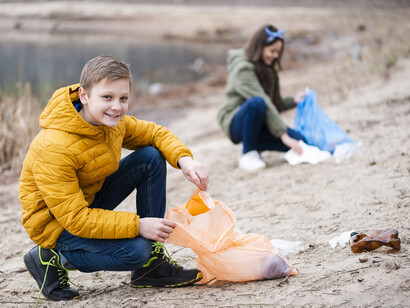 A boy and a girl cleaning a polluted lake