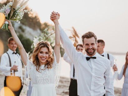 Bride and groom enjoying a joyful beach wedding celebration with guests, creating unforgettable memories by the ocean