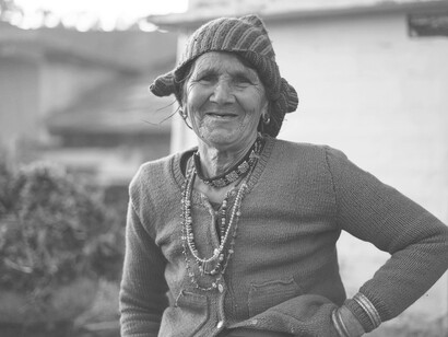 An eldery indigenous woman smiling warly at the camera